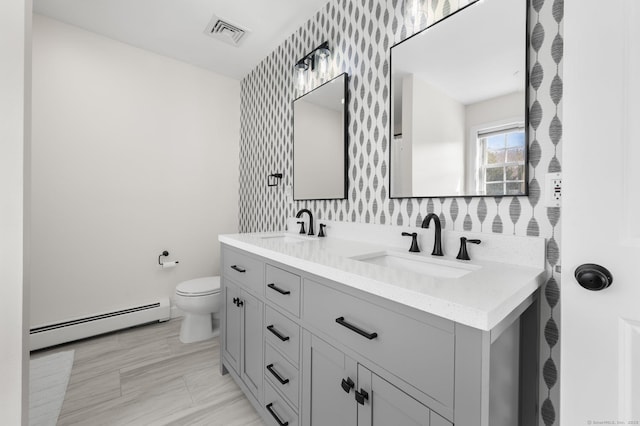 bathroom featuring vanity, toilet, and a baseboard heating unit