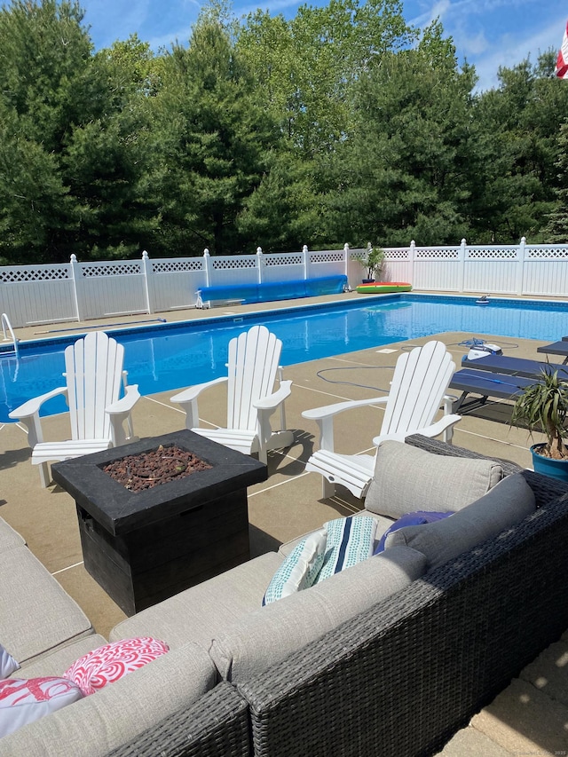 view of pool featuring a patio area and an outdoor living space with a fire pit