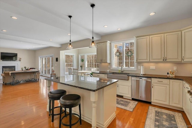 kitchen with sink, dishwasher, hanging light fixtures, a center island, and cream cabinetry