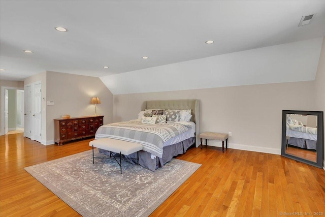 bedroom with hardwood / wood-style flooring and lofted ceiling