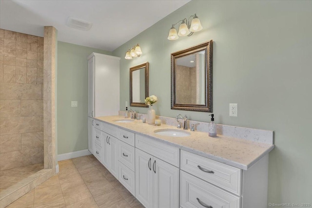 bathroom featuring vanity, tile patterned floors, and tiled shower