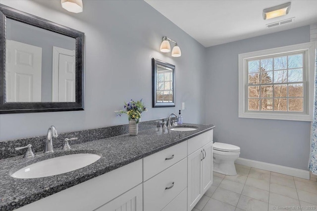 bathroom with tile patterned flooring, vanity, and toilet