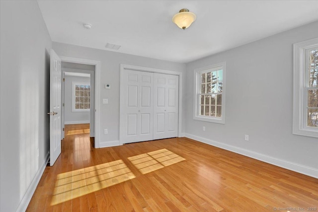 unfurnished bedroom featuring wood-type flooring and a closet