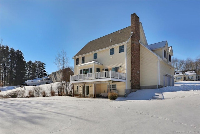 snow covered house featuring a garage