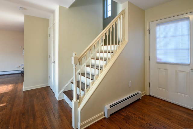 staircase featuring a baseboard heating unit and hardwood / wood-style floors