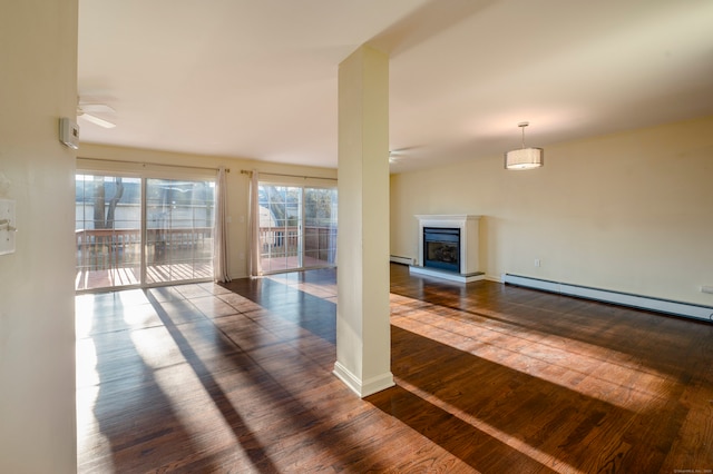 unfurnished living room featuring a baseboard radiator, dark hardwood / wood-style floors, and ceiling fan