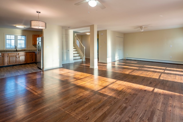 unfurnished room featuring dark wood-type flooring, a baseboard radiator, ceiling fan, and sink