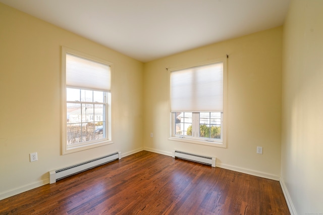 spare room featuring a baseboard radiator and dark hardwood / wood-style floors