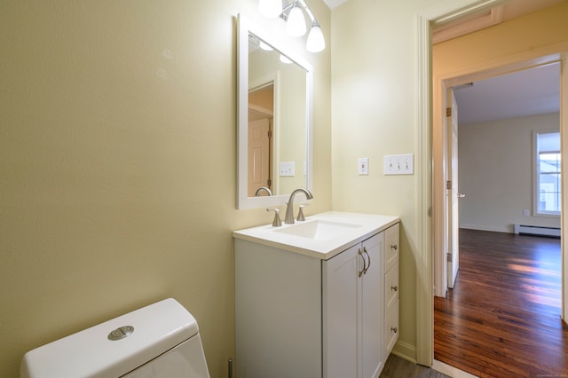 bathroom with vanity, hardwood / wood-style flooring, a baseboard radiator, and toilet