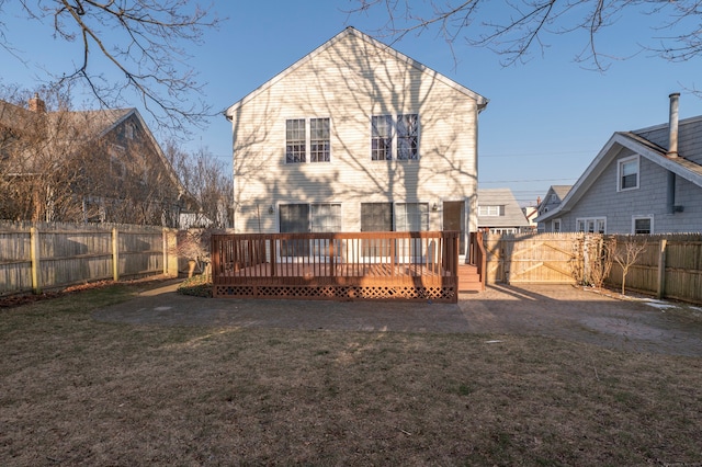 rear view of property featuring a lawn and a deck