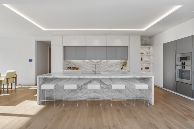 kitchen featuring light wood-style flooring, white cabinets, open shelves, and modern cabinets