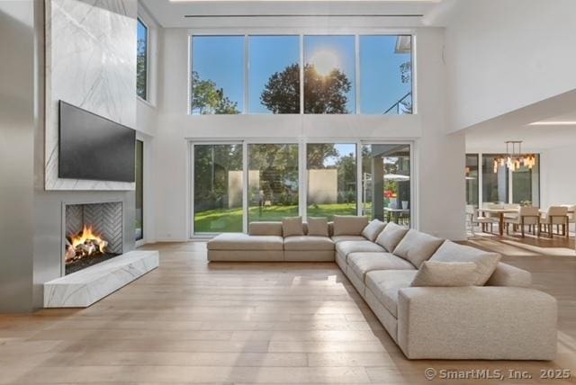 sunroom featuring plenty of natural light, a fireplace, and a chandelier