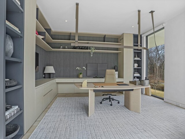 office space with floor to ceiling windows, recessed lighting, built in shelves, and a healthy amount of sunlight