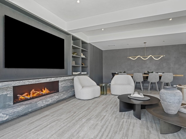 living room with built in features, a fireplace, and beamed ceiling