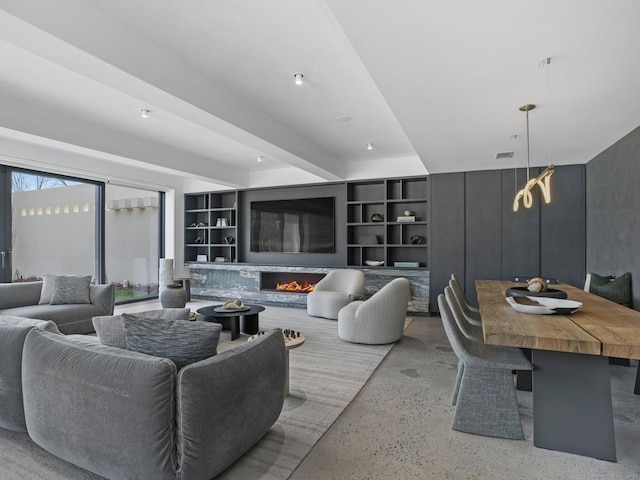 living room with built in shelves, beam ceiling, visible vents, concrete floors, and a lit fireplace