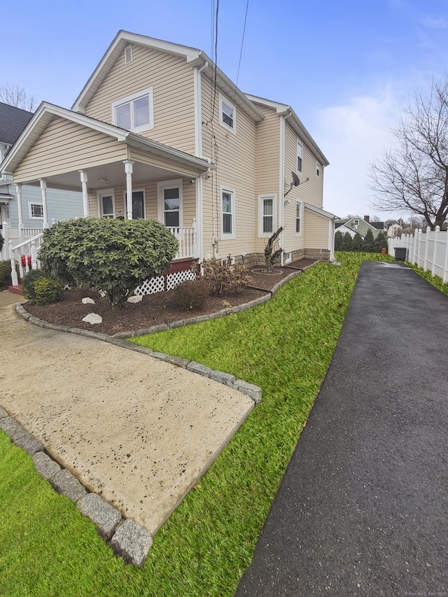 view of property exterior featuring a porch and a yard