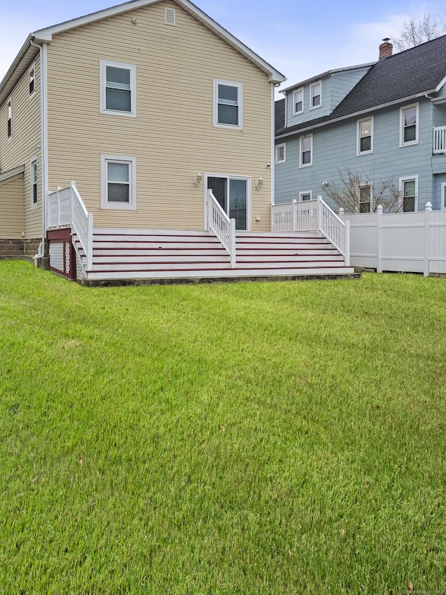 rear view of house with a yard and a deck