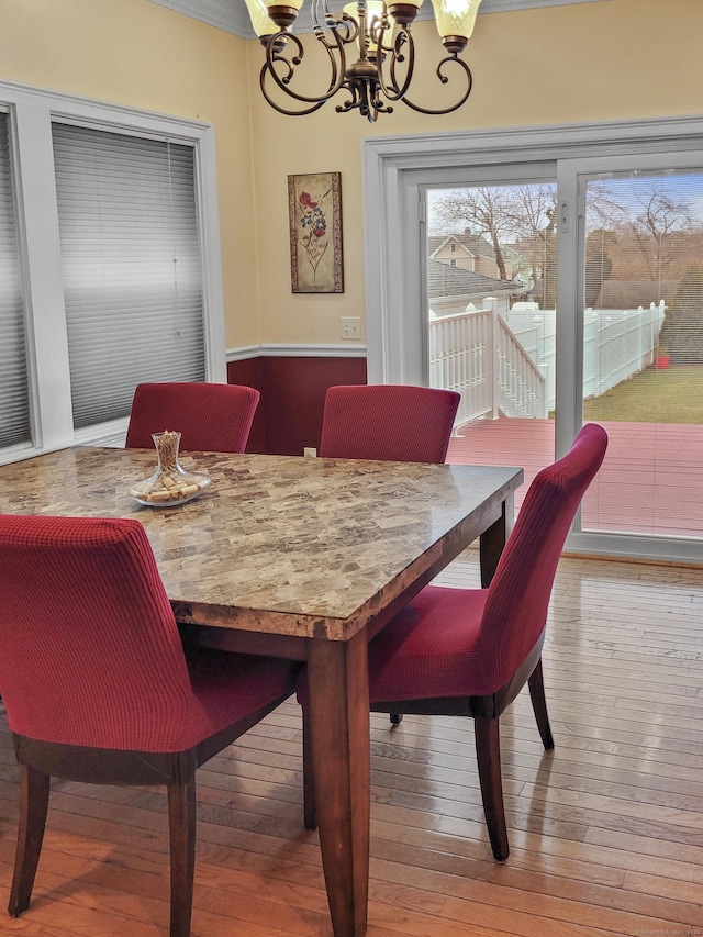 dining area featuring wood-type flooring and a chandelier