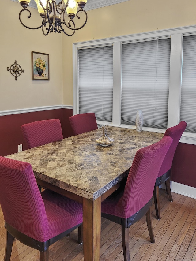 dining room featuring hardwood / wood-style floors, crown molding, and a chandelier