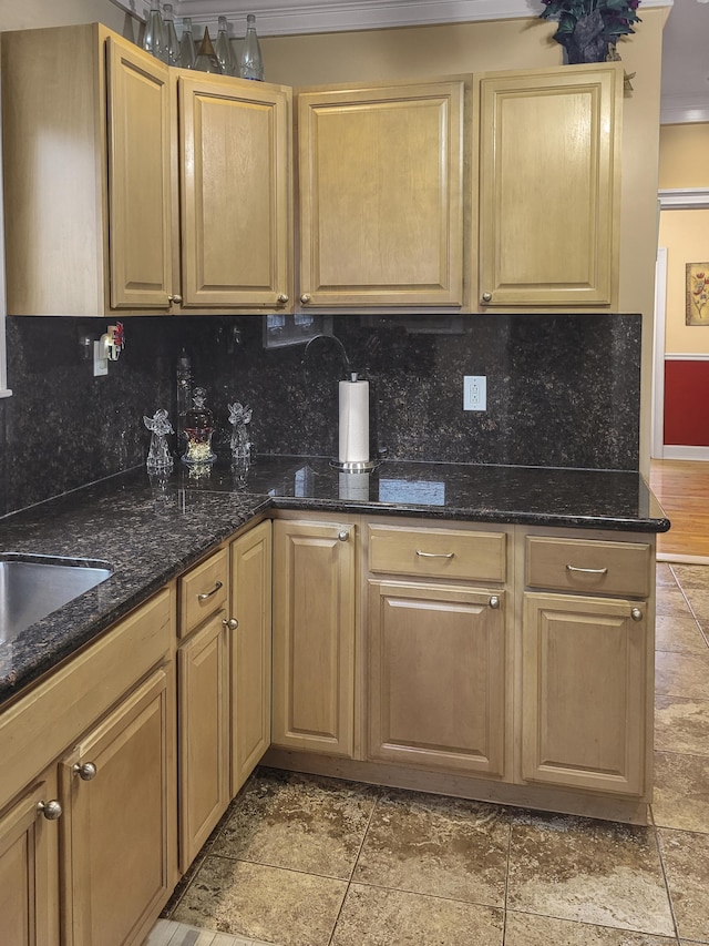 kitchen with dark stone countertops, decorative backsplash, and light brown cabinets