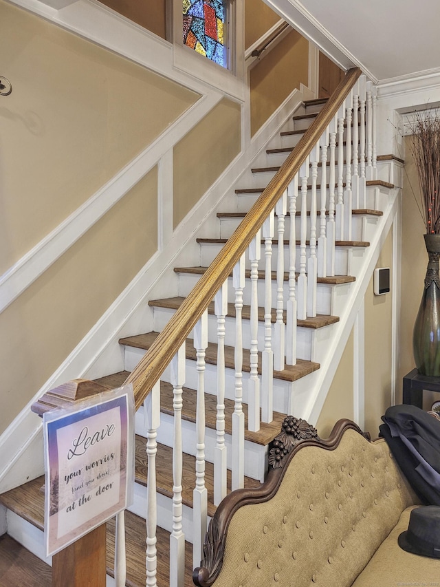 stairs with crown molding and hardwood / wood-style floors