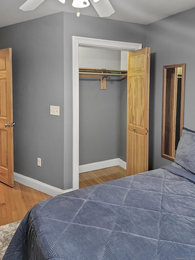 bedroom with ceiling fan, wood-type flooring, and a closet