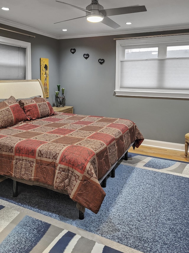 bedroom with ceiling fan, ornamental molding, and wood-type flooring