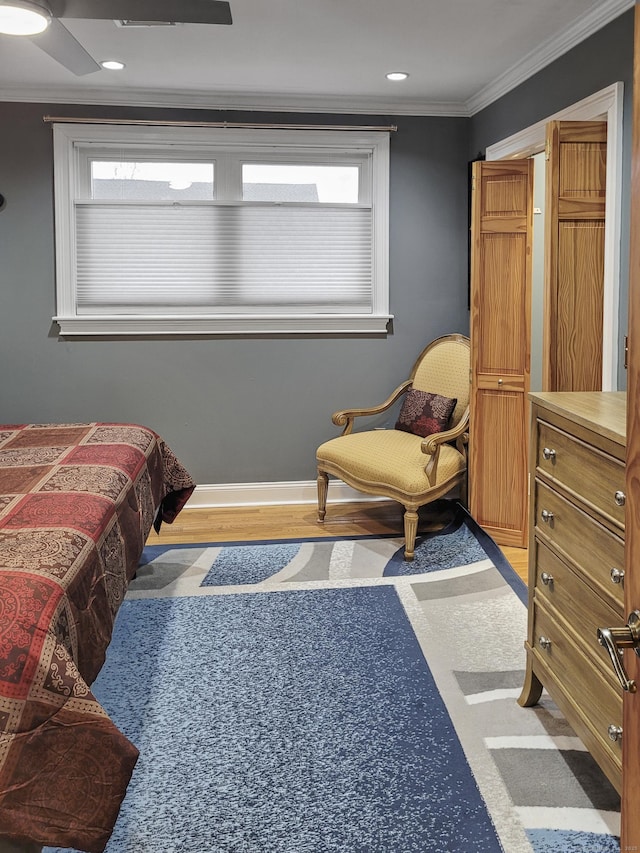 bedroom featuring ceiling fan, ornamental molding, and light hardwood / wood-style floors