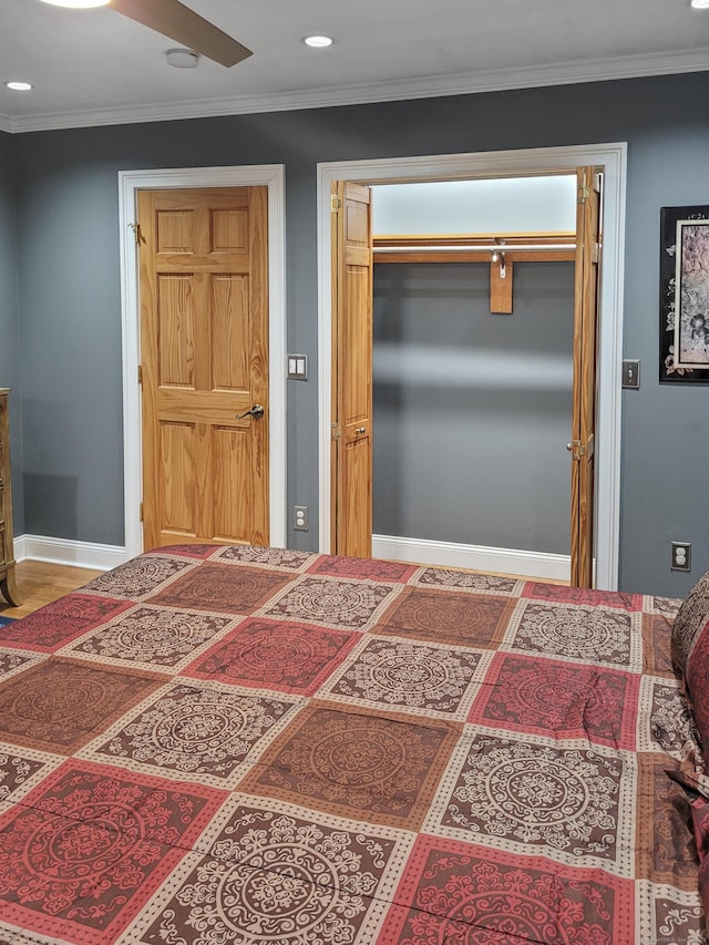 bedroom with crown molding, ceiling fan, and a closet