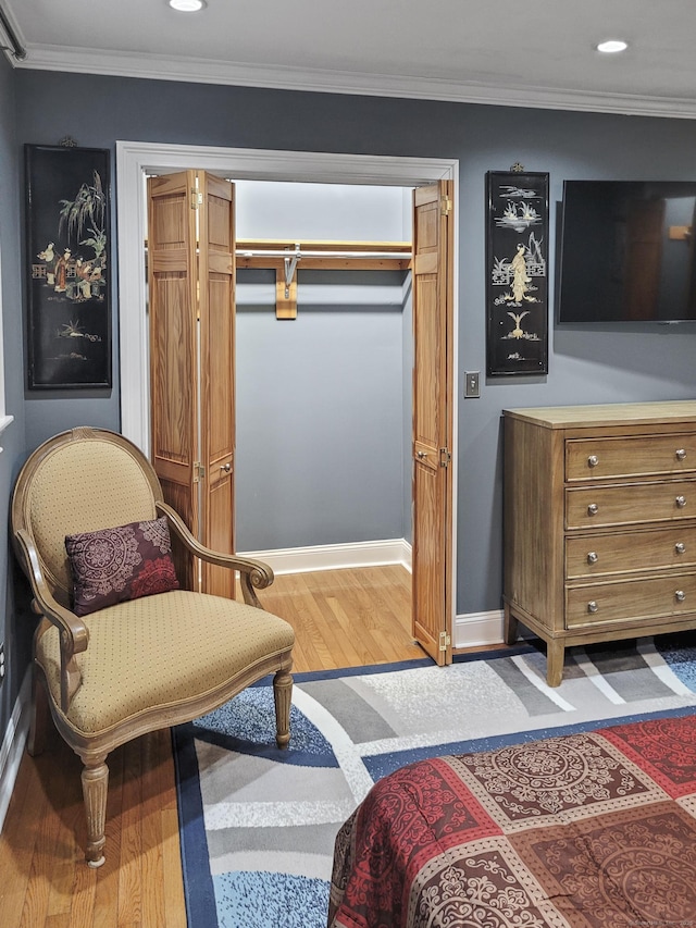 sitting room with hardwood / wood-style flooring and ornamental molding