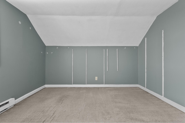 bonus room featuring a baseboard radiator, lofted ceiling, baseboards, and carpet flooring