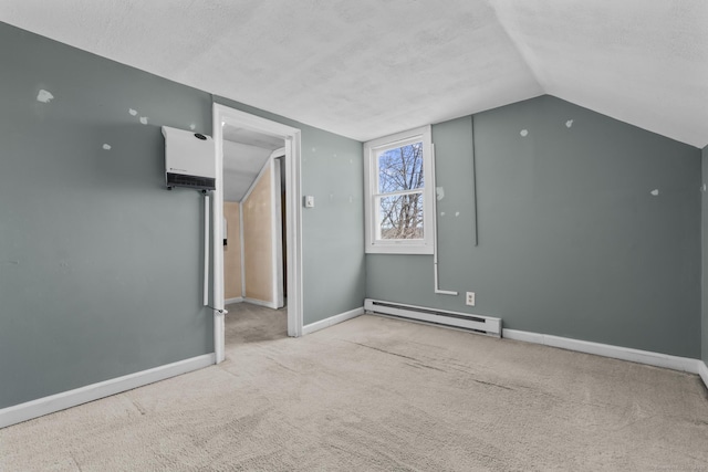 additional living space with lofted ceiling, a baseboard heating unit, a textured ceiling, carpet flooring, and baseboards