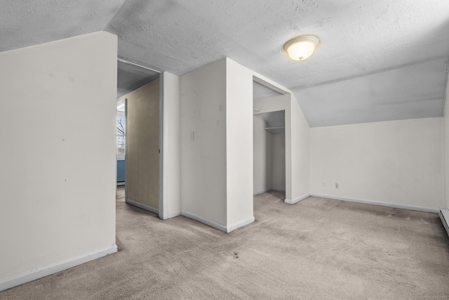 bonus room featuring baseboards, carpet floors, a textured ceiling, and vaulted ceiling