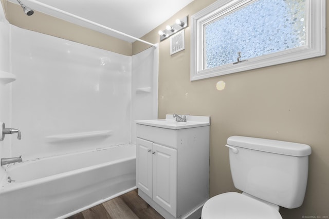 bathroom with vanity, wood finished floors, visible vents, shower / bathing tub combination, and toilet