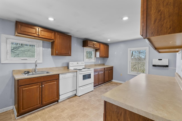 kitchen featuring a sink, recessed lighting, white appliances, brown cabinetry, and light countertops