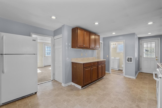 kitchen with recessed lighting, a healthy amount of sunlight, white appliances, and light countertops