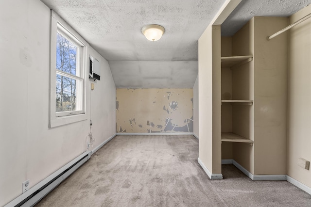 interior space featuring a textured ceiling, vaulted ceiling, carpet, and a baseboard radiator