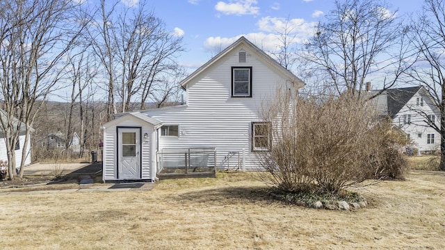 rear view of property featuring a yard