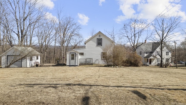 rear view of house with a yard and an outbuilding