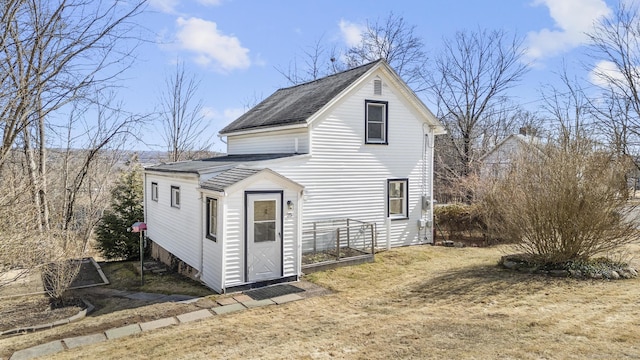 back of house with a shingled roof