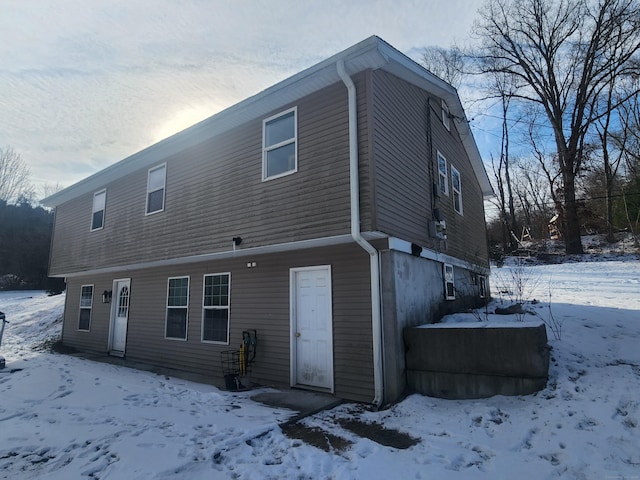 view of snow covered rear of property