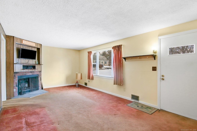 unfurnished living room featuring a fireplace, carpet flooring, and a textured ceiling