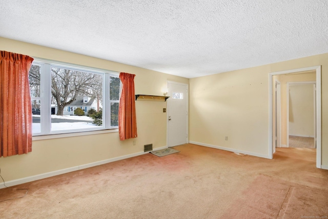 interior space featuring a textured ceiling and light colored carpet