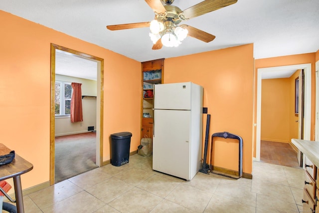 kitchen with white fridge, light tile patterned floors, and a textured ceiling