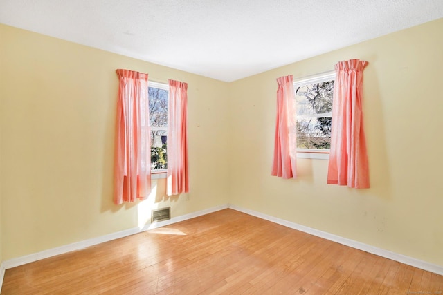 spare room with wood-type flooring and a textured ceiling