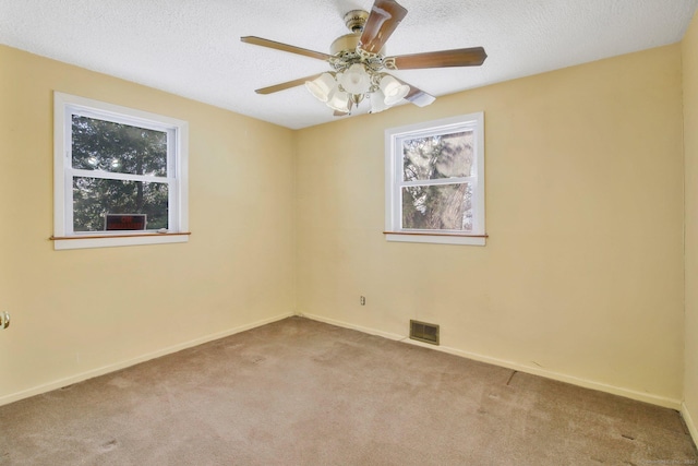 empty room with a textured ceiling, light carpet, and ceiling fan