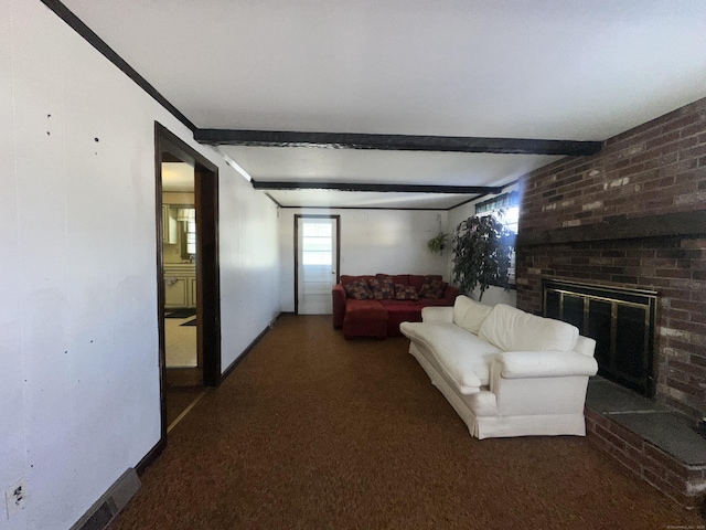 carpeted living room with a brick fireplace and beam ceiling