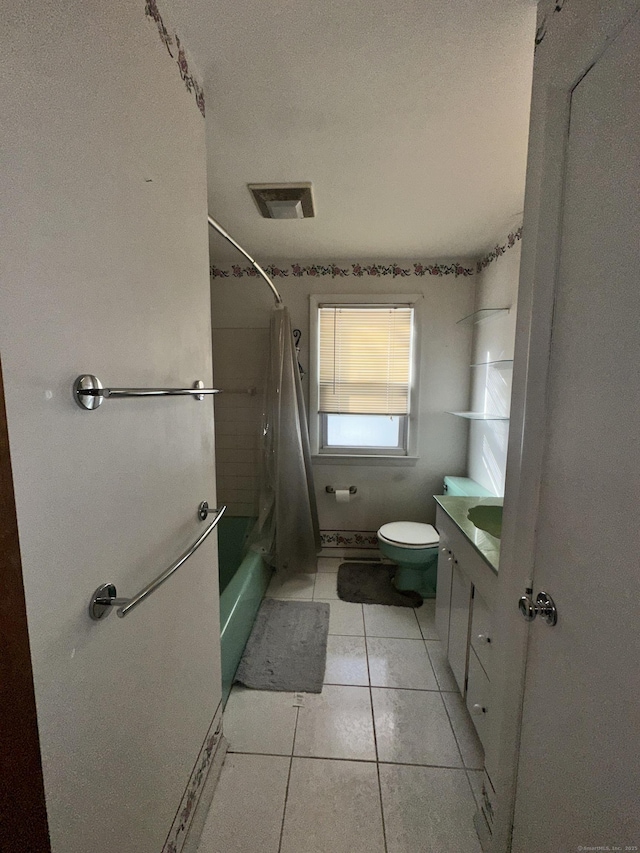 full bathroom featuring tile patterned flooring, vanity, a textured ceiling, toilet, and shower / bath combo with shower curtain