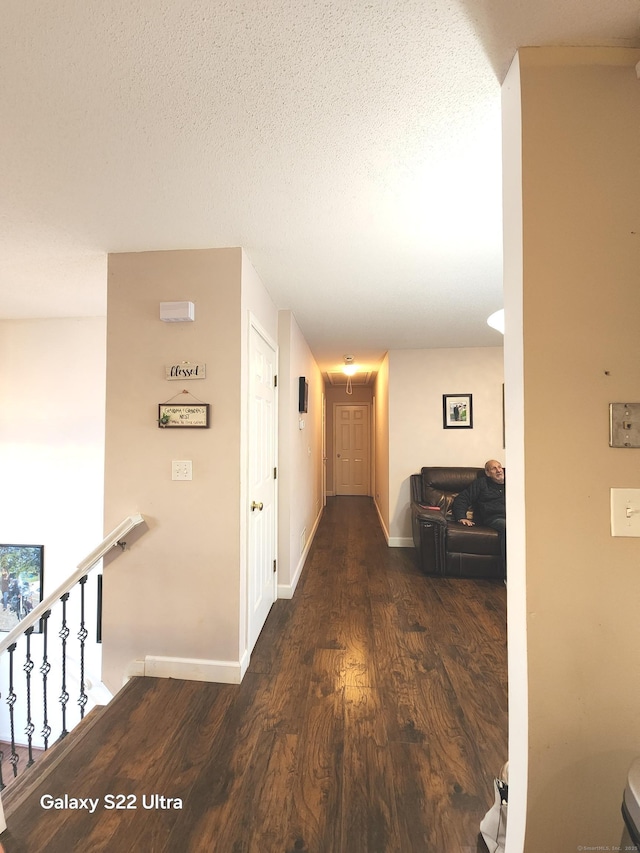 hallway featuring dark hardwood / wood-style floors and a textured ceiling