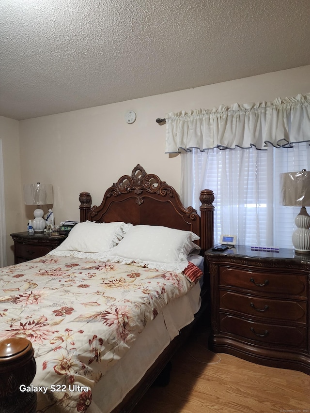 bedroom with light hardwood / wood-style flooring and a textured ceiling